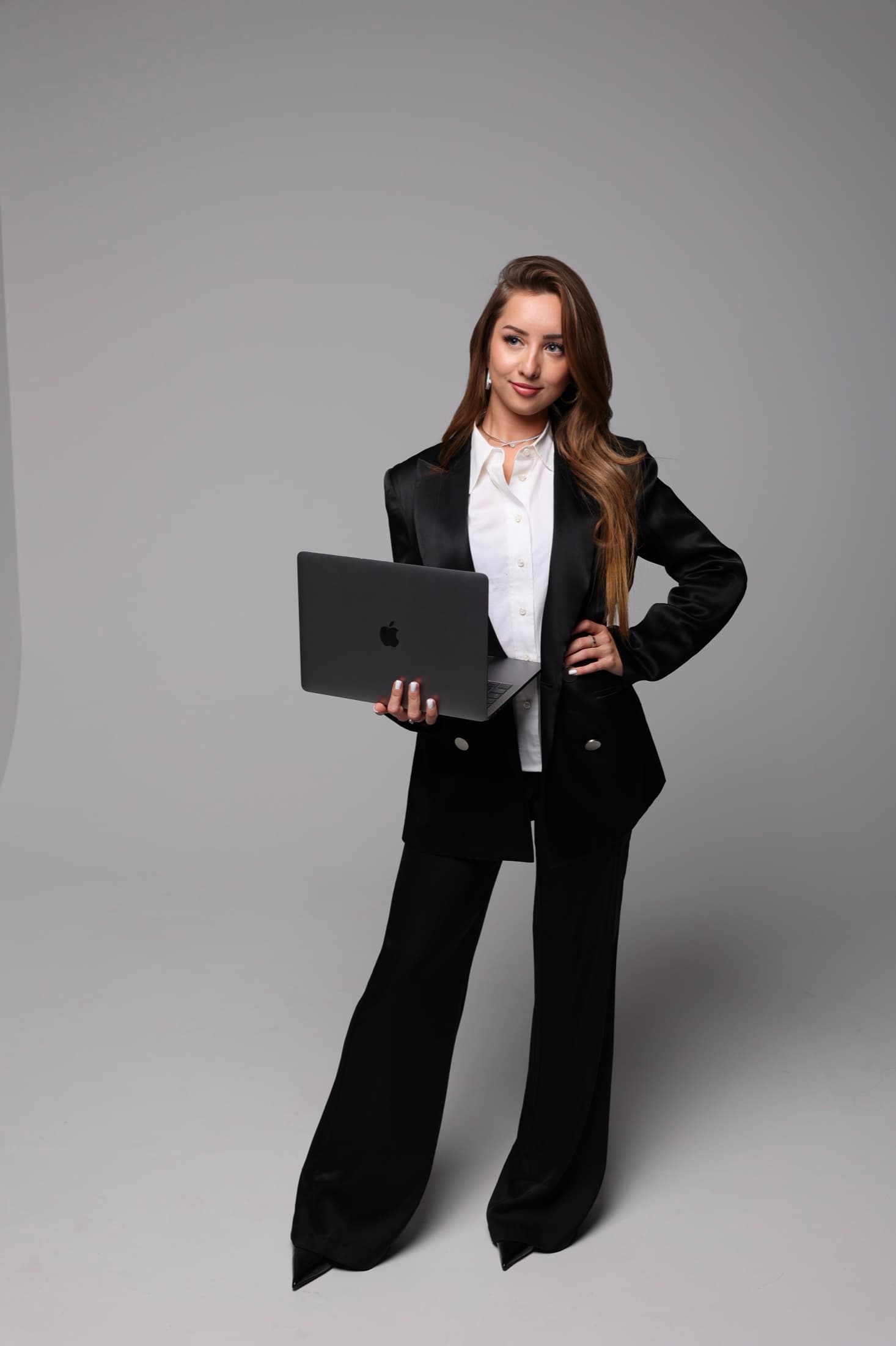Dasha Brandt im schwarzen Anzug mit Laptop